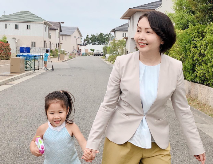 子供と手をつなぎ歩く孝岡知子氏